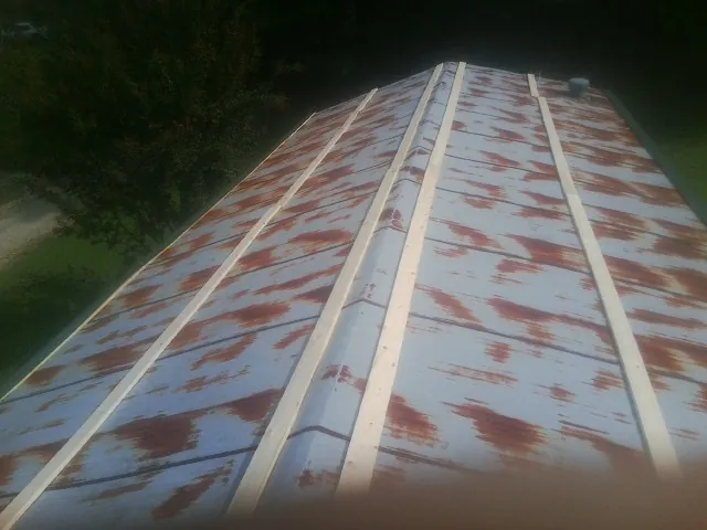 Rusted metal roof panels with new wood purlins before replacement — Storm Damage Roof Repair in Buda by Roofing Brothers