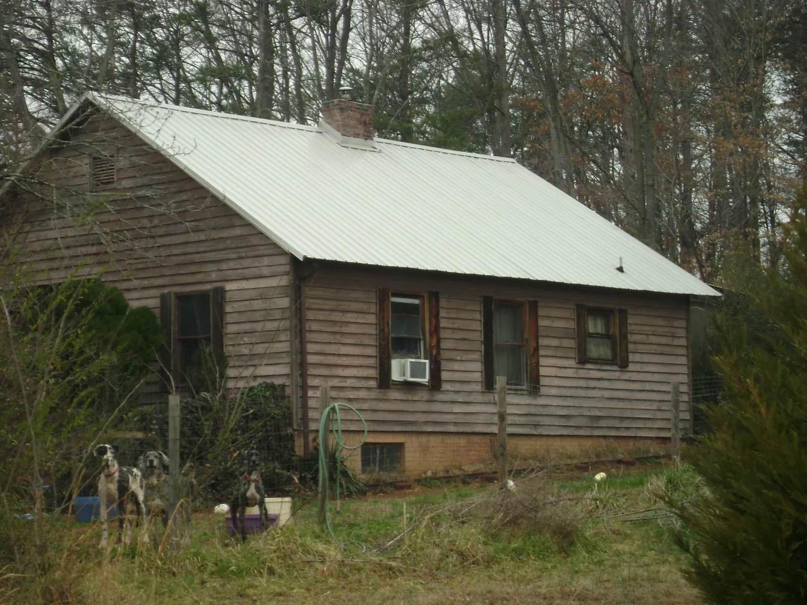 White metal roof on an old wood sided farmhouse, from a Metal Roof Installation job in Buda